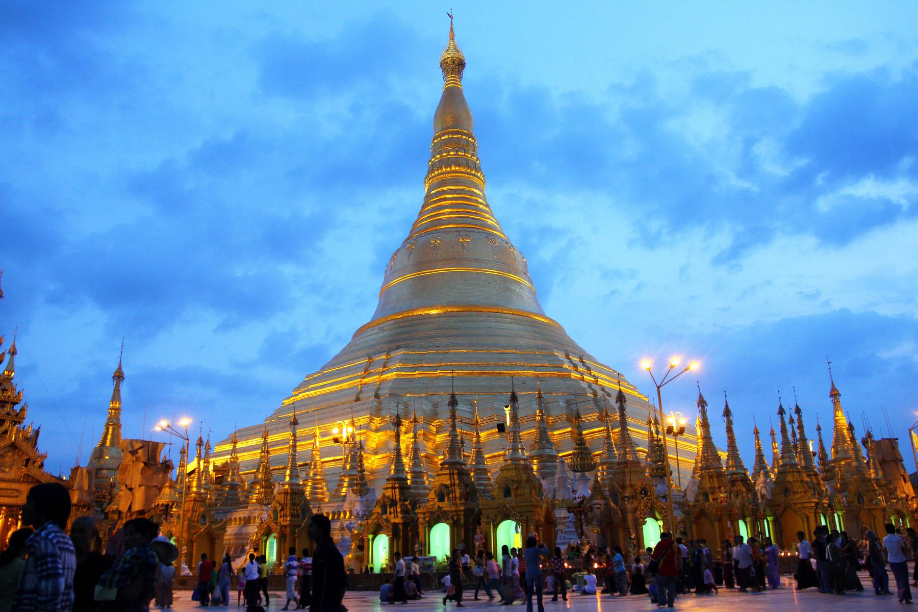 I skymningen flockas många troende vid Shwedagon pagoden i Yangon