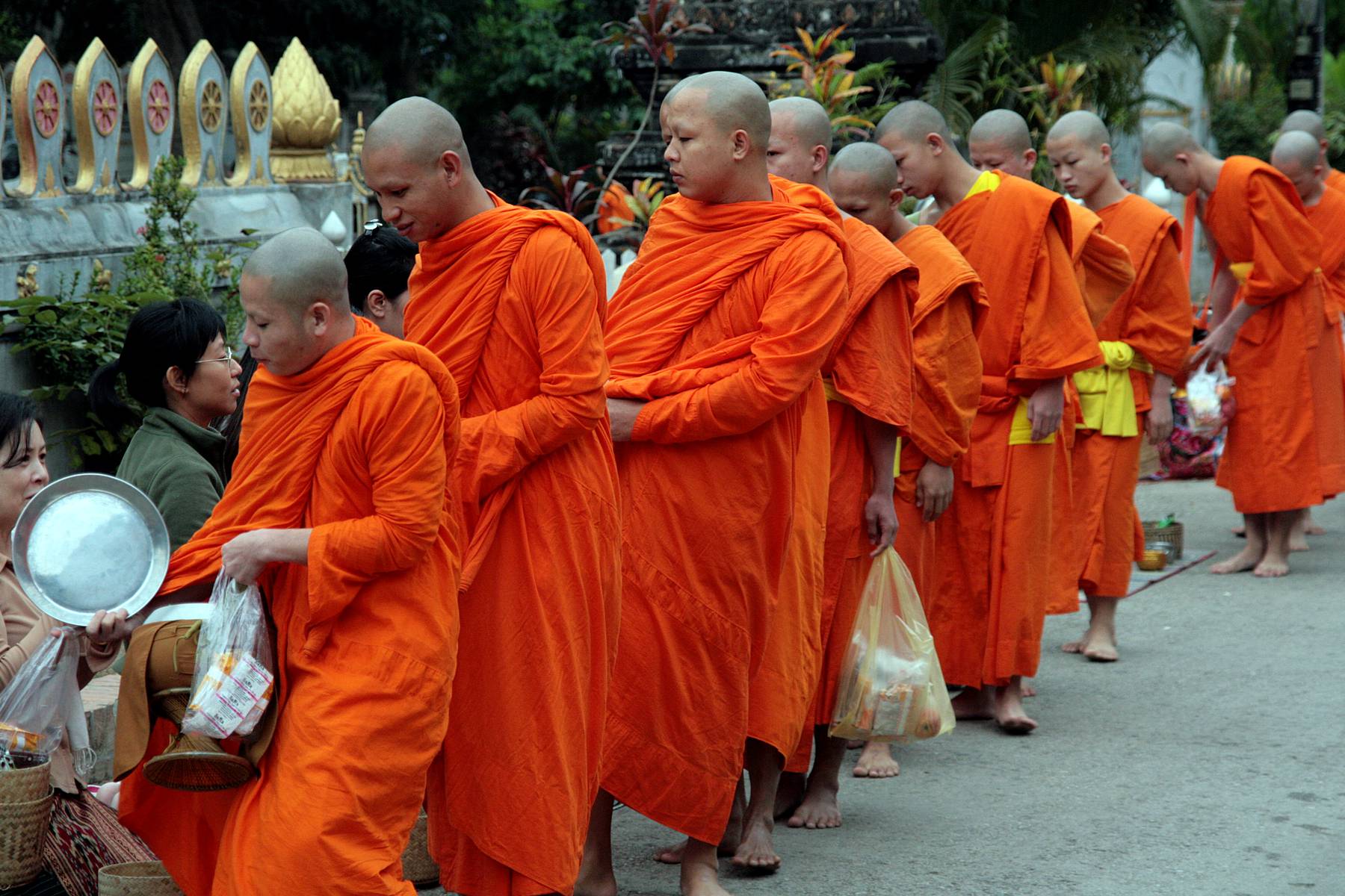 Munkar går sin tiggarrunda före soluppgången i Luang Prabang
