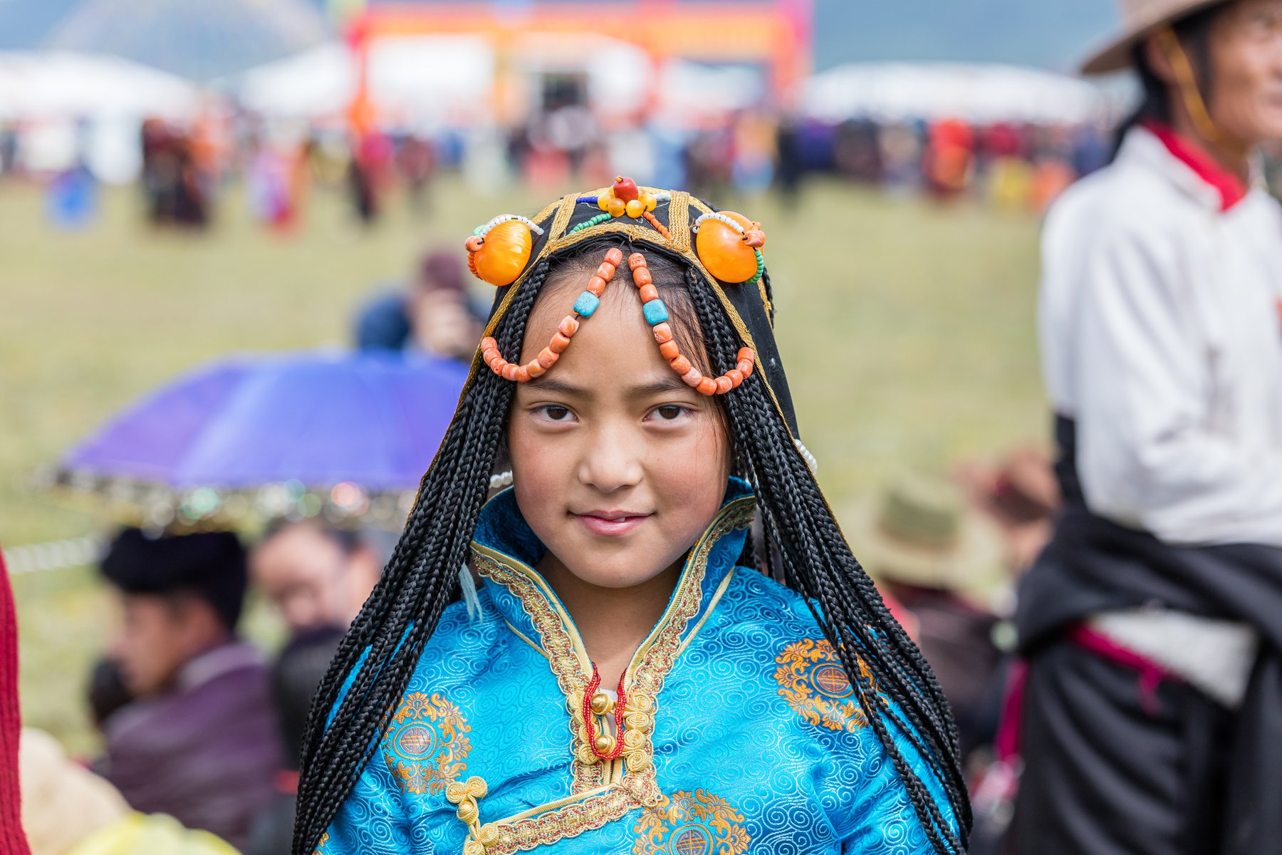 Ung kvinna i traditionella kläder under hästfestivalen väster om Litang