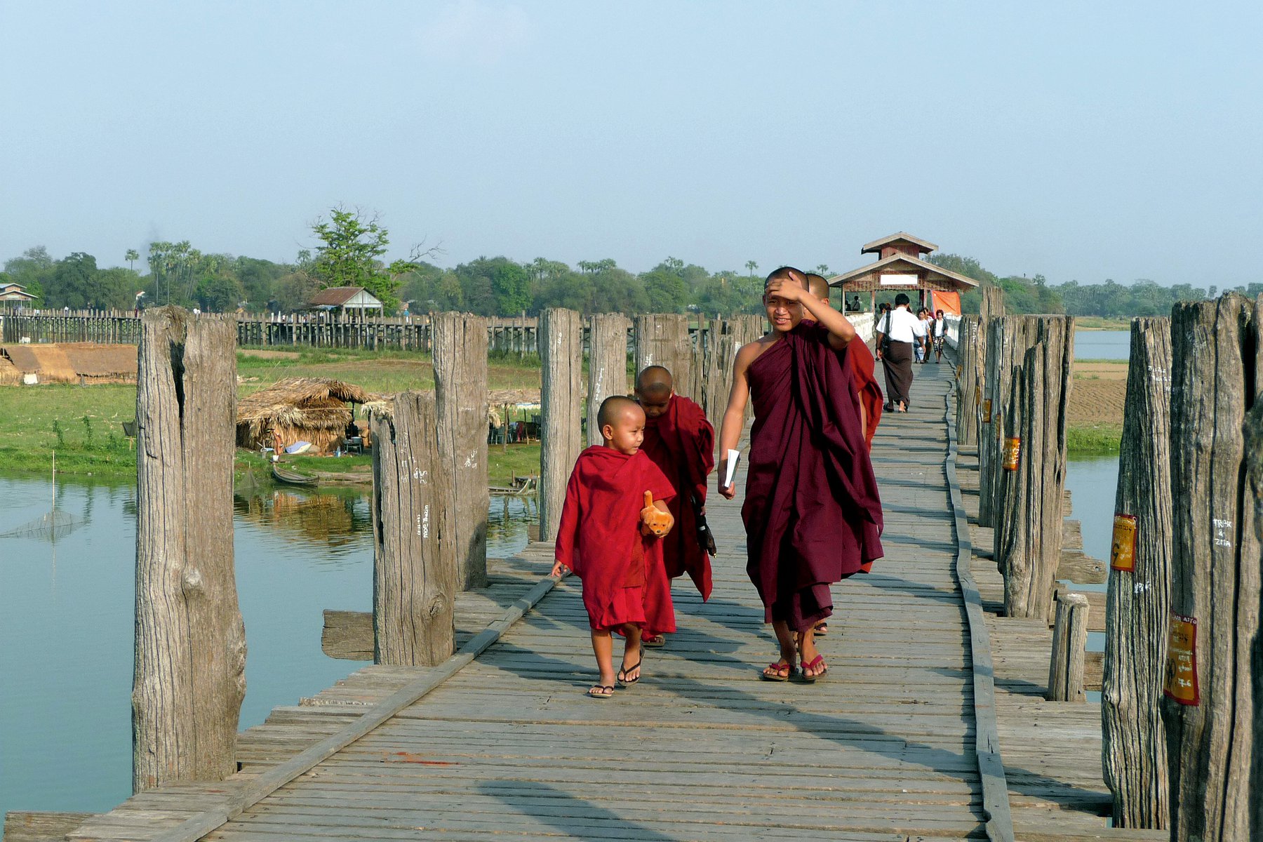Munkar på U Bein teak-bron utanför Mandalay