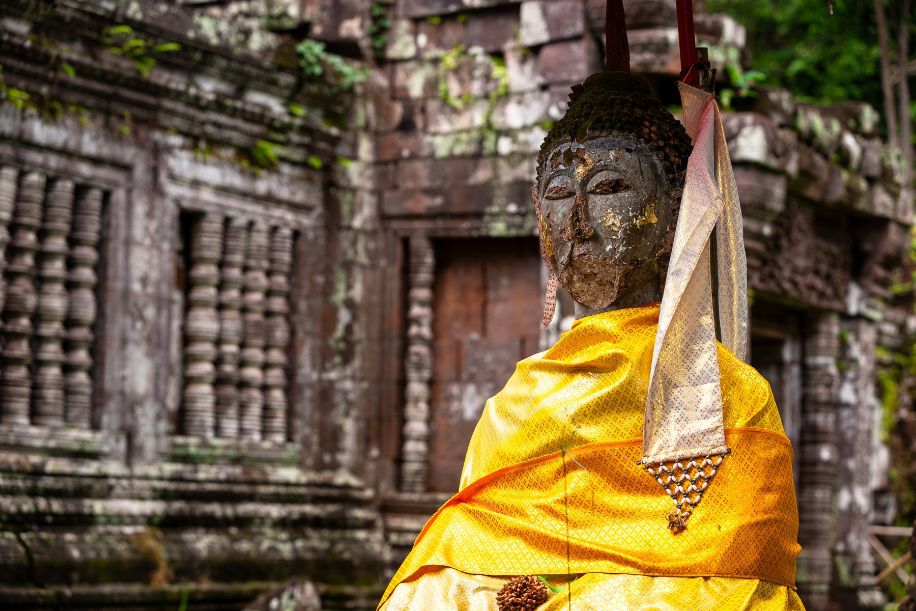 Gamla Buddhastatyer pryder ruinerna av det khmeriska templet Vat Phou