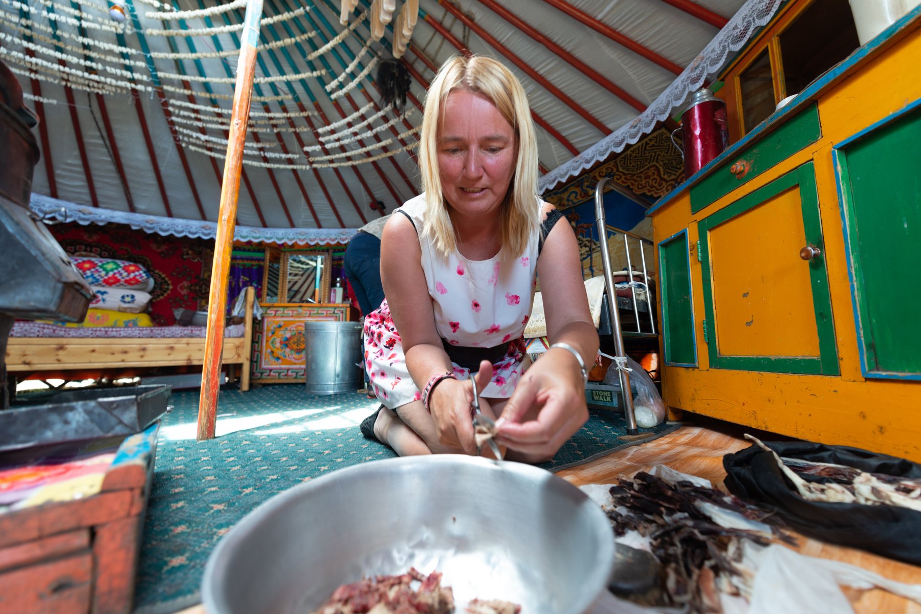 Karin hjälper till med middagen inne i sin ger