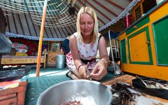 Karin hjälper till med middagen inne i sin ger