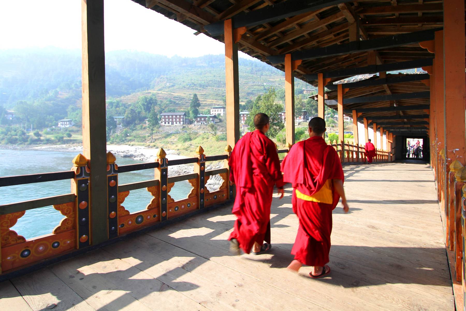 Munkar på träbron vid Punakha Dzong