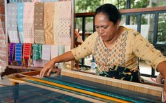 En lokal hantverkskvinna väver ett traditionellt tyg i Labuan Bajo